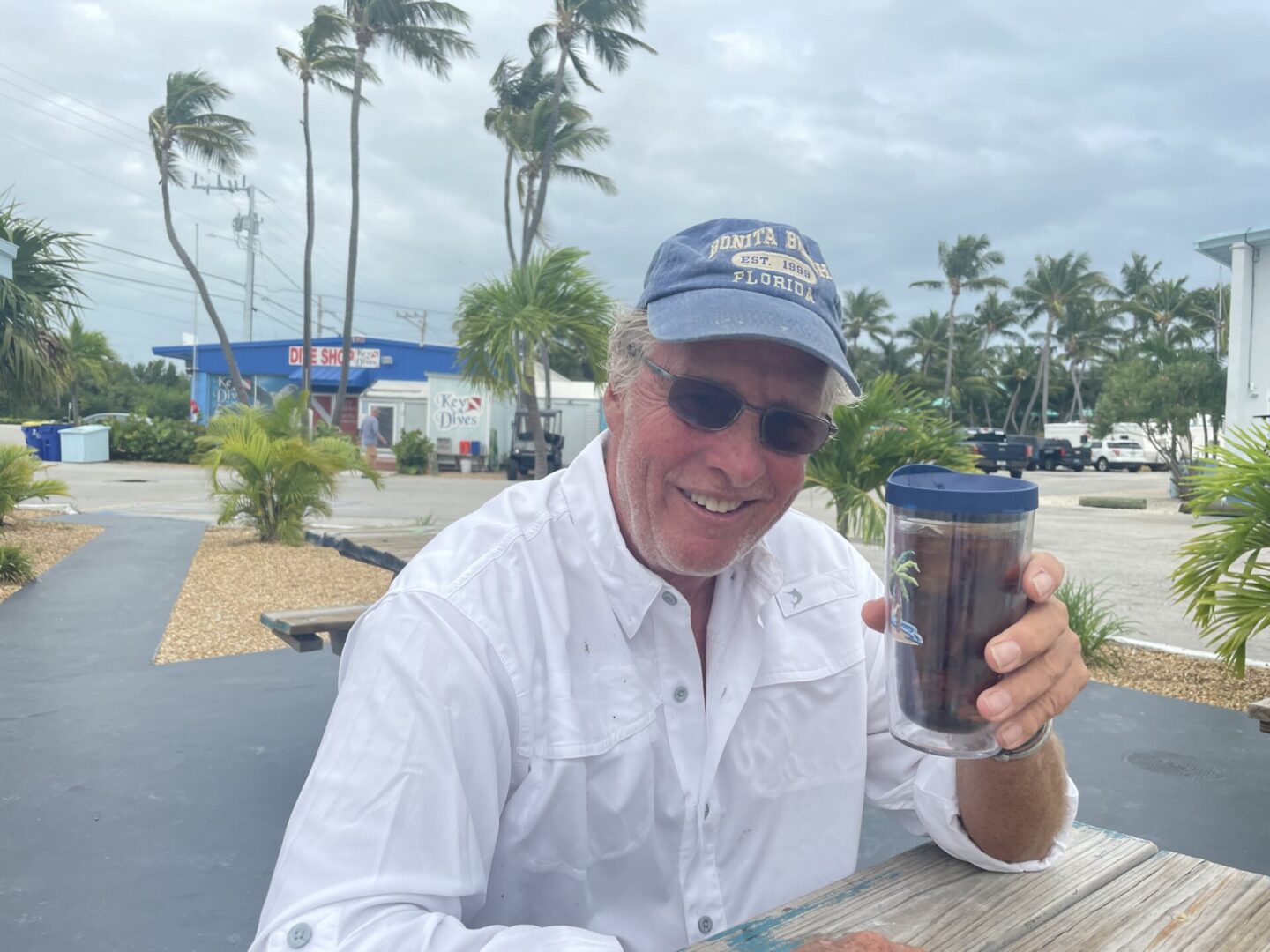 A man sitting at a table with a cup of coffee.