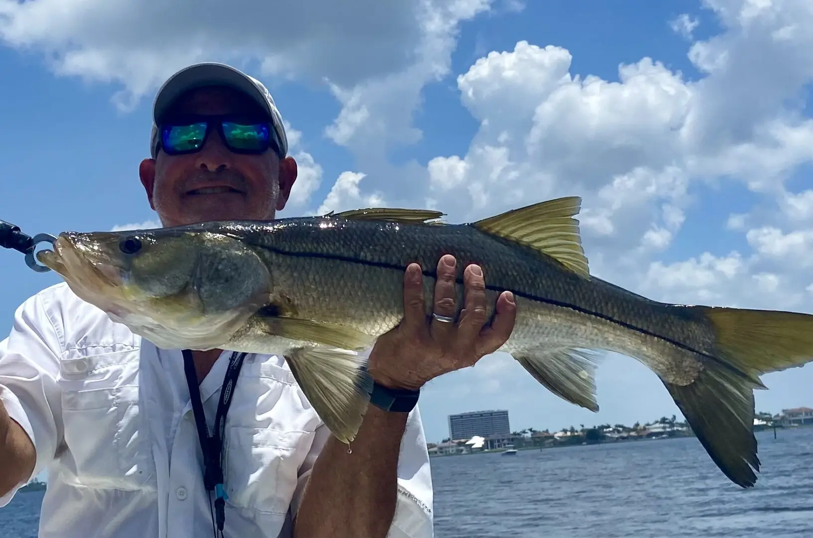 A man in sunglasses holding a fish