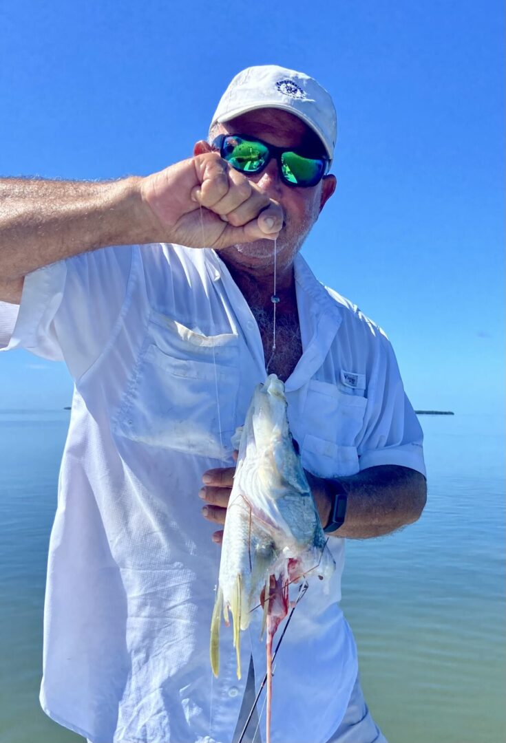 A man holding up a fish in the water.